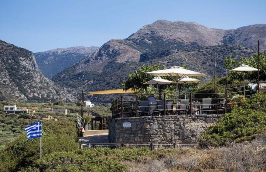 Gyroscopio's stone terrace seen from the valley with Cretan mountains behind